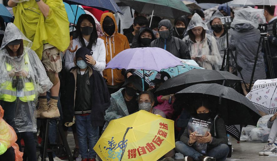 Protesters sit down near an umbrella with the words "Support freedom, Against Evil Law" during a rally in Hong Kong on Sunday, Dec. 29, 2019. Protests that began in June over a proposed extradition law have spread to include demands for more democracy and other grievances. (AP Photo/Lee Jin-man)