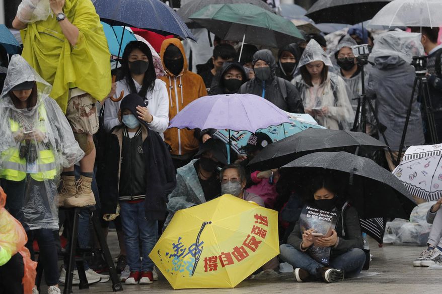 Protesters sit down near an umbrella with the words "Support freedom, Against Evil Law" during a rally in Hong Kong on Sunday, Dec. 29, 2019. Protests that began in June over a proposed extradition law have spread to include demands for more democracy and other grievances. (AP Photo/Lee Jin-man)