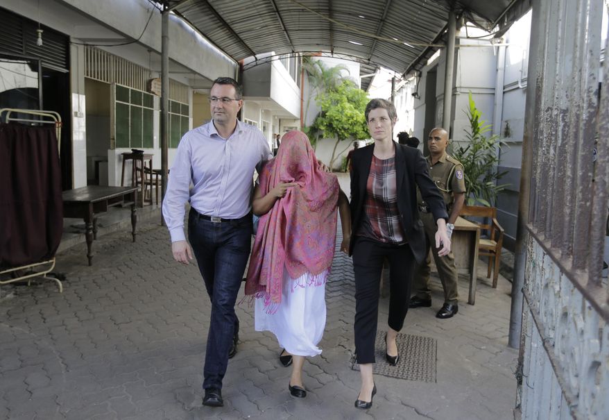 A Swiss Embassy employee who was detained pending charges that she made statements to create disaffection toward the government and fabricated evidence, center, walks out with two unidentified embassy employees after getting bail in Colombo, Sri Lanka, Monday, Dec. 30, 2019. (AP Photo/Eranga Jayawardena)