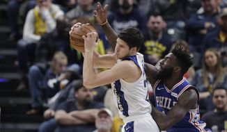 Indiana Pacers&#39; Doug McDermott (20) grabs a rebound against Philadelphia 76ers&#39; Norvel Pelle (14) during the first half of an NBA basketball game, Tuesday, Dec. 31, 2019, in Indianapolis. (AP Photo/Darron Cummings)