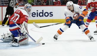 Washington Capitals goaltender Braden Holtby (70) reaches out for a shot by New York Islanders center Mathew Barzal (13) during the first period of an NHL hockey game, Tuesday, Dec. 31, 2019, in Washington. (AP Photo/Nick Wass)