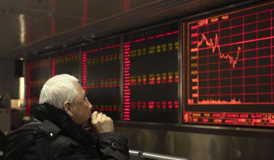 An investor monitors stock prices at a brokerage in Beijing on Tuesday, Dec. 31, 2019. Asian shares were lower in quiet New Year's Eve trading, with many markets closed. Tuesday's declines tracked a broad retreat overnight on Wall Street that erased some of the major indexes’ recent gains, though the market remains on track to end the year with its best performance since 2013. (AP Photo/Ng Han Guan)