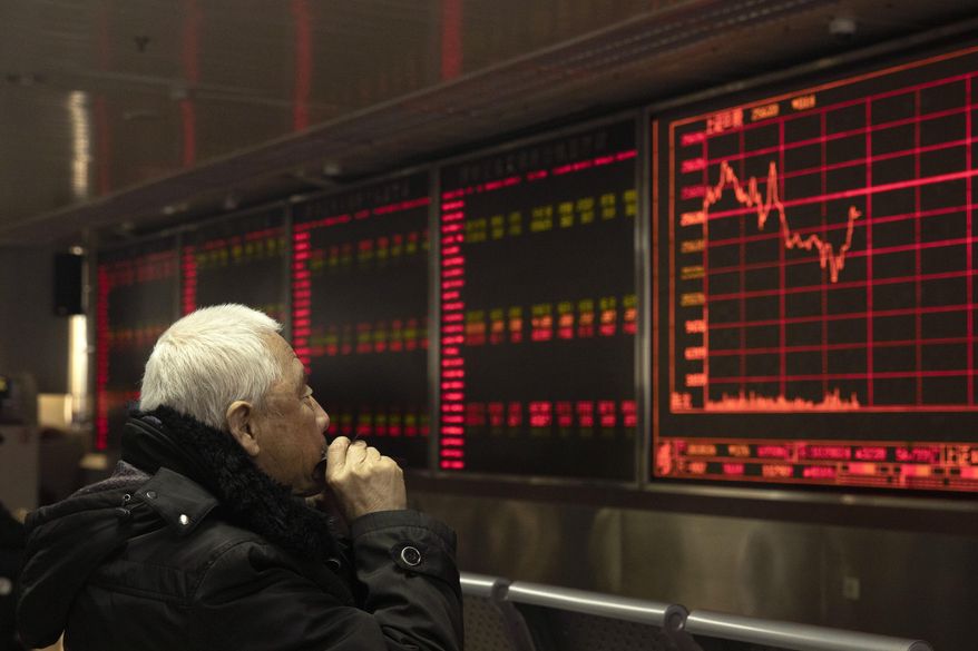 An investor monitors stock prices at a brokerage in Beijing on Tuesday, Dec. 31, 2019. Asian shares were lower in quiet New Year's Eve trading, with many markets closed. Tuesday's declines tracked a broad retreat overnight on Wall Street that erased some of the major indexes’ recent gains, though the market remains on track to end the year with its best performance since 2013. (AP Photo/Ng Han Guan)