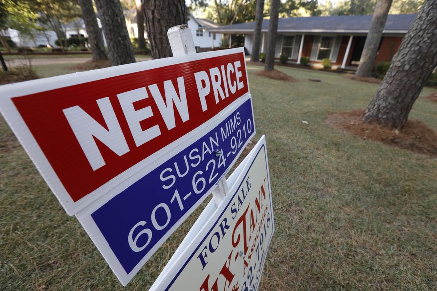 FILE - This Sept. 25, 2019, photo shows a sign indicating a new selling price for a house sits atop a realtor's sign in Jackson, Miss. On Tuesday, Dec. 31, the Standard & Poor's/Case-Shiller 20-city home price index for October is released. (AP Photo/Rogelio V. Solis)
