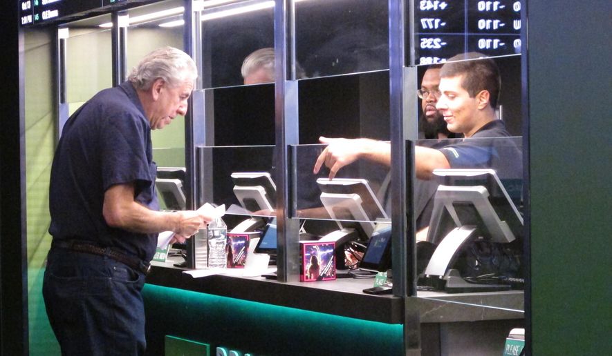 In this Oct. 8, 2019 photo, a man makes a sports bet at Resorts casino in Atlantic City, N.J. In November 2019, New Jersey&#39;s casinos and racetracks took in nearly $563 million worth of sports bets, a new monthly record. (AP Photo/Wayne Parry)