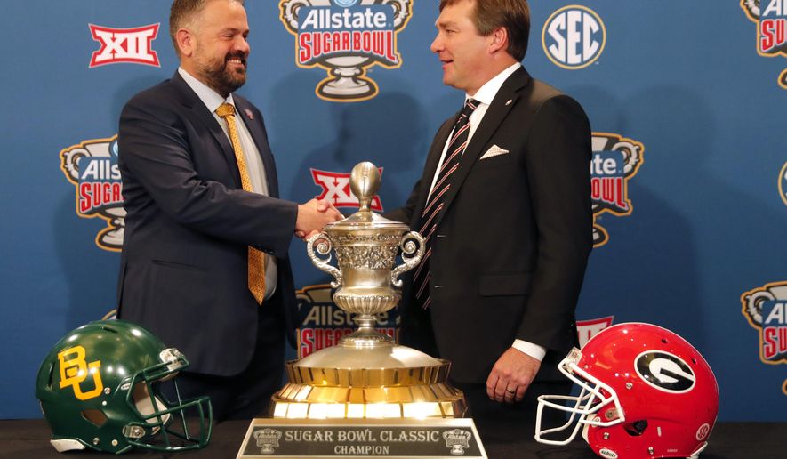 Georgia head coach Kirby Smart, right, and Baylor head coach Matt Rhule shake hands as they pose with the trophy during a Sugar Bowl NCAA college news conference in New Orleans, Tuesday, Dec. 31, 2019. The two teams meet on New Year's Day. (AP Photo/Gerald Herbert)
