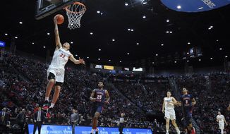 San Diego State guard Malachi Flynn (22) goes to the basket as Fresno State guard Anthony Holland (25) looks on during the second half of an NCAA college basketball game Wednesday, Jan. 1, 2020, in San Diego. San Diego won 61-52. (AP Photo/Orlando Ramirez)