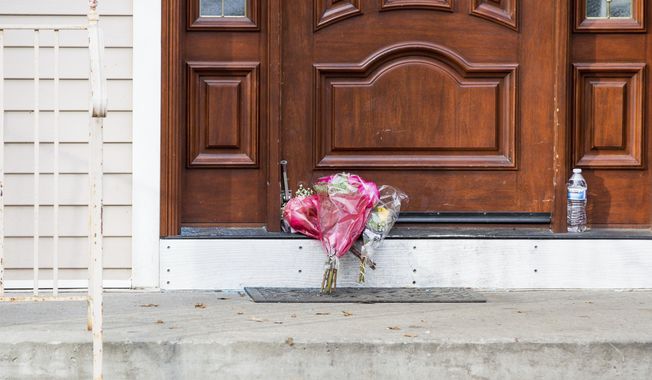 Flower bouquets rest on the doorstep of a rabbi&#x27;s residence in Monsey, N.Y., Sunday, Dec. 29, 2019, following a stabbing Saturday night during a Hanukkah celebration. (AP Photo/Julius Constantine Motal)