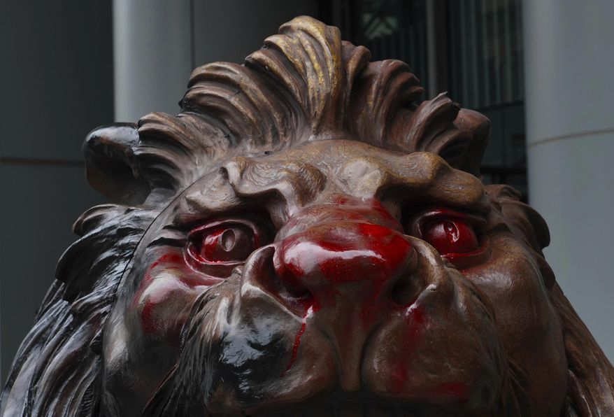 The lion statue in front of the international HSBC Bank branch is covered with red paint in Hong Kong, Thursday, Jan. 2, 2020. A huge crowd gathered in Hong Kong Wednesday for an annual New Year's Day protest march as the months long pro-democracy movement extends into 2020. (AP Photo/Vincent Yu)