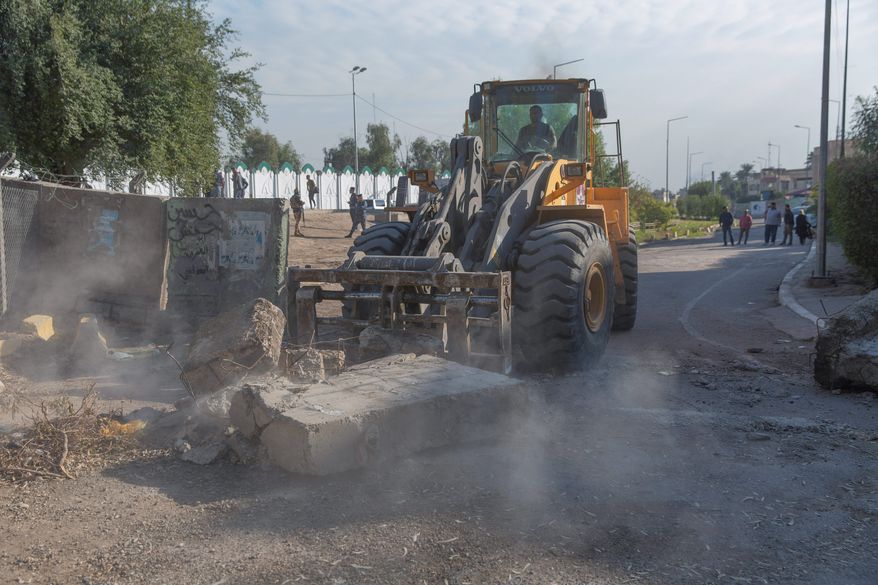 Iraqi security forces removed concrete blocks and opened streets that were closed for security concerns around the Green Zone in Baghdad on Thursday. A raid by Iran-backed militiamen has only elevated tensions between Washington and Tehran. (Associated Press)