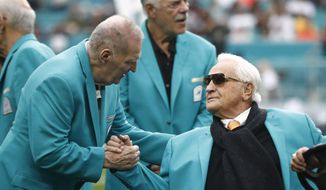 Former Miami Dolphins head coach Don Shula is greeted on the field by former players during half time at an NFL football game against the Cincinnati Bengals, Sunday, Dec. 22, 2019, in Miami Gardens, Fla. The 1972 undefeated team was celebrated on the field. (AP Photo/Brynn Anderson)