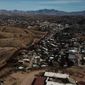 The U.S. border fence separates Nogales, Mexico, right, from sister city Nogales, Arizona, left, Friday, Jan. 3, 2020. Dozens of asylum seekers pushed back into Mexico by the United States tried Friday to get their bearings still unsure of how they would travel some 350 miles to their court dates in El Paso, subsist for months in this unfamiliar border city or return to their distant homelands. (AP Photo/Luis Enrique Castillo)