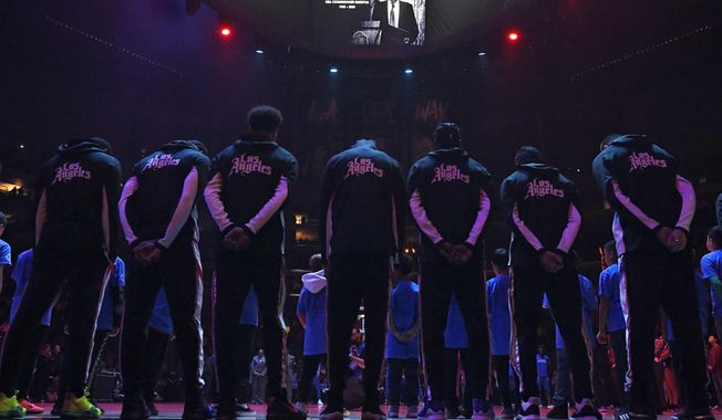 Members of the Los Angeles Clippers stand duringa a moment of silence Thursday, Jan. 2, 2020, in Los Angeles, prior to a basketball game against the Detroit Pistons, for former NBA Commissioner David Stern, who died Wednesday as a result of the brain hemorrhage. (AP Photo/Mark J. Terrill)