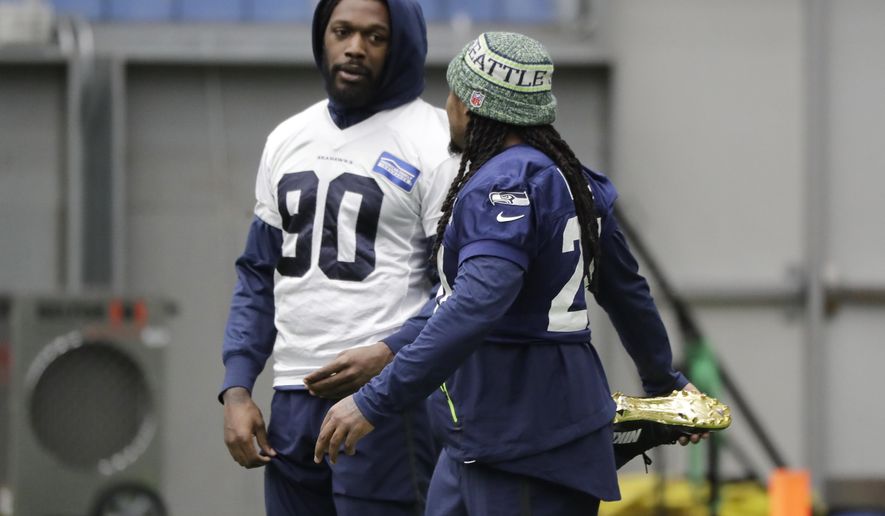 Seattle Seahawks running back Marshawn Lynch, right, stretches as he talks with defensive end Jadeveon Clowney, left, before NFL football practice, Friday, Dec. 27, 2019, in Renton, Wash. (AP Photo/Ted S. Warren)