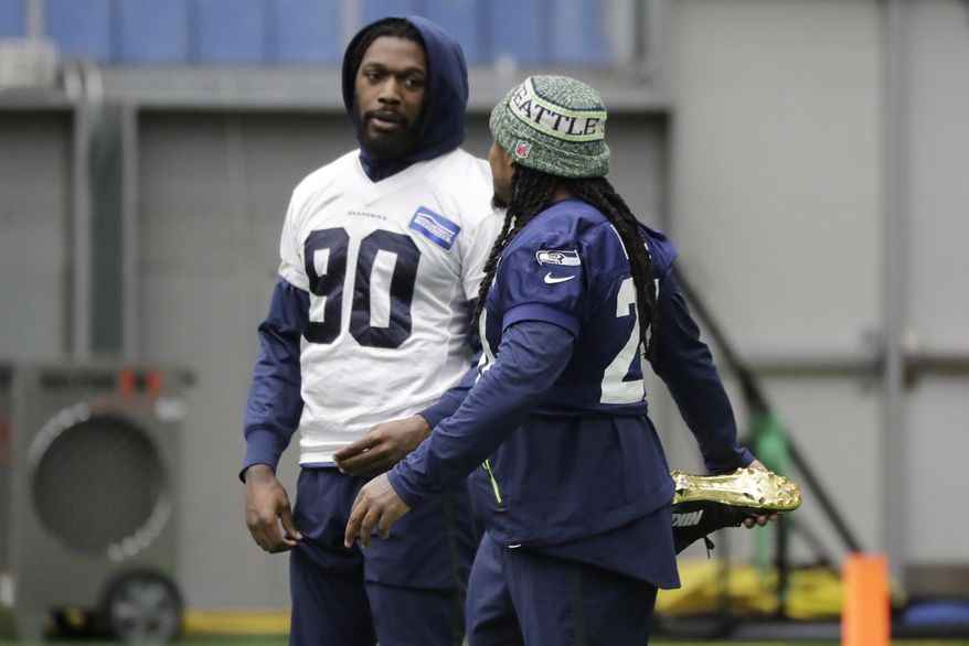 Seattle Seahawks running back Marshawn Lynch, right, stretches as he talks with defensive end Jadeveon Clowney, left, before NFL football practice, Friday, Dec. 27, 2019, in Renton, Wash. (AP Photo/Ted S. Warren)