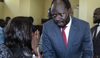 FILE - In this Tuesday, June 11, 2019 file photo, prominent South Sudanese activist and economist Peter Biar Ajak prepares to embrace his wife Nyathon Hoth Mai, left, as she weeps after he was sentenced to two years in prison, in a courtroom in the capital Juba, South Sudan. A lawyer said Friday, Jan 3, 2020 that the prominent South Sudan activist and economist has not been freed from prison despite being pardoned in a presidential decree. (AP Photo/Sam Mednick, File)