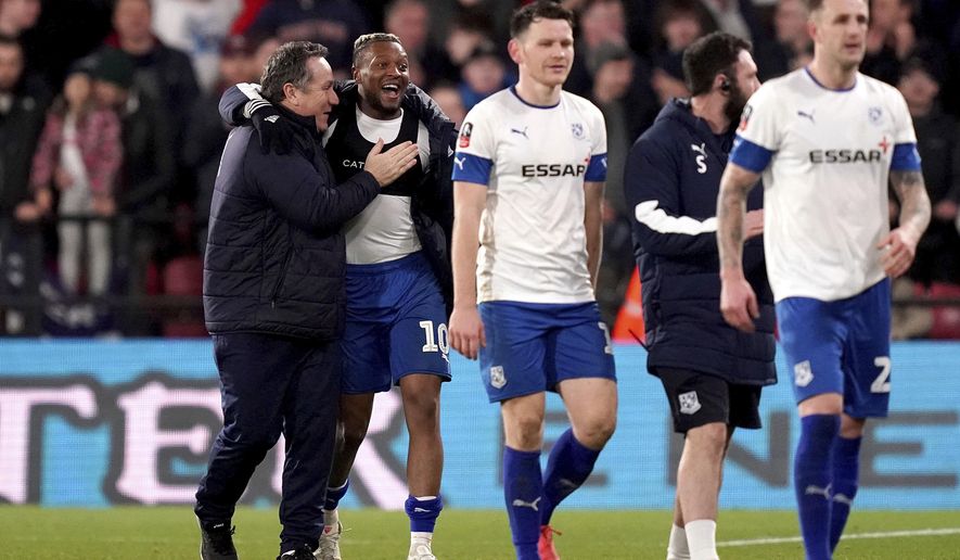 Tranmere Rovers manager Micky Mellon, left, celebrates with Morgan Ferrier after his side earn a replay with a draw following the English FA Cup third round soccer match between Watford and Tranmere Rovers at Vicarage Road, Watford, England, Saturday, Jan. 4, 2020. (John Walton/PA via AP)