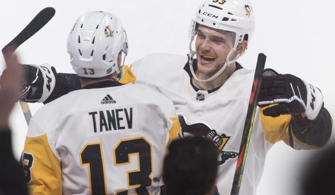 Pittsburgh Penguins&#x27; Brandon Tanev (13) celebrates with teammate Teddy Blueger after scoring during overtime in an NHL hockey game against the Montreal Canadiens, Saturday, Jan. 4, 2020 in Montreal. (Graham Hughes/The Canadian Press via AP)