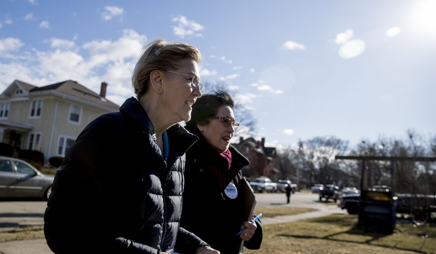 Democratic presidential candidate Sen. Elizabeth Warren, D-Mass., left, accompanied by Jackson County Democratic Party chair Donna Duvall, right, knocks on doors to speak to undecided caucus goers, Sunday, Jan. 5, 2020, in Maquoketa, Iowa. (AP Photo/Andrew Harnik)