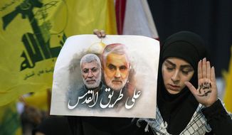 A supporter of Hezbollah leader Sayyed Hassan Nasrallah wears the words &amp;quot;powerful revenge&amp;quot; on her hand, ahead of the leader&#39;s televised speech in a southern suburb of Beirut, Lebanon, Sunday, Jan. 5, 2020 following the U.S. airstrike in Iraq that killed Iranian Revolutionary Guard Gen. Qassem Soleimani. The placard in her other hand depicts Soleimaini and Iraq&#39;s Popular Mobilization forces commander Abu Mahdi al-Muhandis, who was also killed in the strike. Arabic on placard reads: &amp;quot;On the road to Jerusalem.&amp;quot; (AP Photo/Maya Alleruzzo)