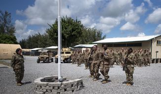 In this photo taken Aug. 26, 2019 and released by the U.S. Air Force, airmen from the 475th Expeditionary Air Base Squadron conduct a flag-raising ceremony, signifying the change from tactical to enduring operations, at Camp Simba, Manda Bay, Kenya. The al-Shabab extremist group said Sunday, Jan. 5, 2020 that it has attacked the Camp Simba military base used by U.S. and Kenyan troops in coastal Kenya, while Kenya&#39;s military says the attempted pre-dawn breach was repulsed and at least four attackers were killed. (Staff Sgt. Lexie West/U.S. Air Force via AP)