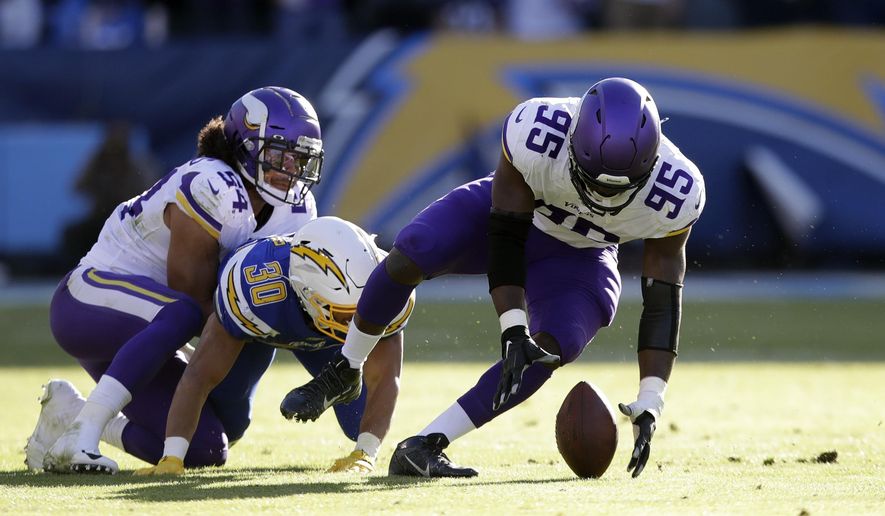 Minnesota Vikings defensive end Ifeadi Odenigbo, right, recovers a fumble before running it back for a touchdown during the first half of an NFL football game against the Los Angeles Chargers, Sunday, Dec. 15, 2019, in Carson, Calif. (AP Photo/Marcio Jose Sanchez)