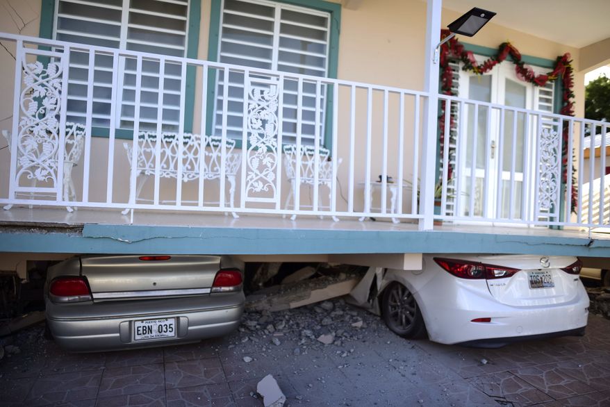 Cars are crushed under a home that collapsed after an earthquake hit Guanica, Puerto Rico, Monday, Jan. 6, 2020. A 5.8-magnitude quake hit Puerto Rico before dawn Monday, unleashing small landslides, causing power outages and severely cracking some homes. There were no immediate reports of casualties. (AP Photo/Carlos Giusti)