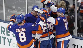New York Islanders left wing Anders Lee (27), second from right with his back against the glass, celebrates with teammates, including defenseman Noah Dobson (8), left wing Michael Dal Colle (28), and center Derick Brassard (10) after scoring a goal during the third period of an NHL hockey game, Monday, Jan. 6, 2020, in Uniondale, N.Y. The Islanders defeated the Avalanche 1-0 on Lee&#39;s game-winning goal. (AP Photo/Kathy Willens)