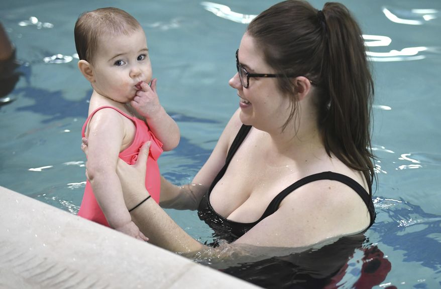 In this Dec. 12, 2019 photo, Leah Spring works with her daughter Juniper, 1, of Livonia, during a swim lesson at the Goldfish Swim School in Canton, Mich. (Max Ortiz/Detroit News via AP)