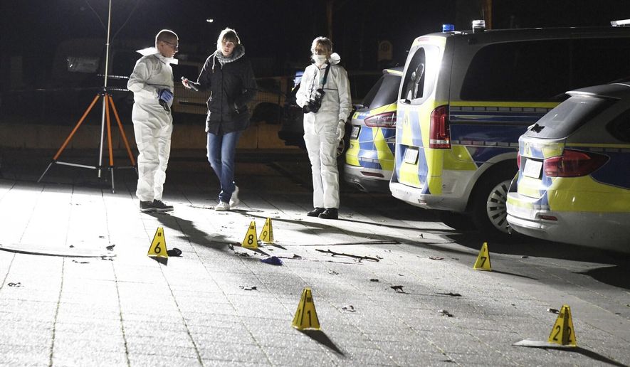 Police officers investigate inside a cordoned-off area in front of a police station in Gelsenkirchen, Germany, late Sunday, Jan. 5, 20120. A 23-year-old police inspector candidate shot dead a man on Sunday evening as the man attempted to assault officers with an object and a knife. (Stephan Witte/dpa via AP)