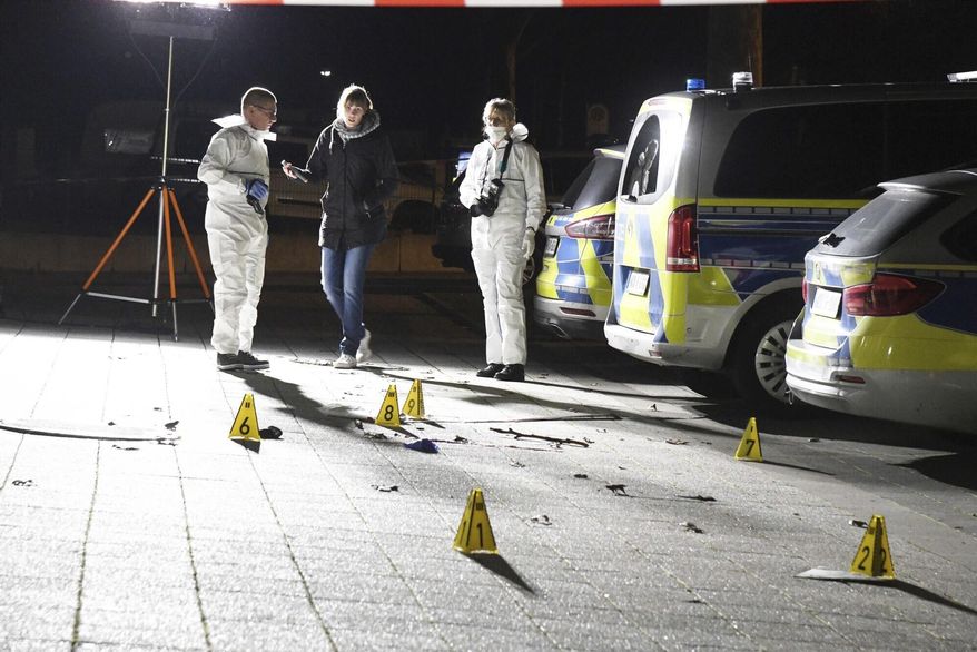 Police officers investigate inside a cordoned-off area in front of a police station in Gelsenkirchen, Germany, late Sunday, Jan. 5, 20120. A 23-year-old police inspector candidate shot dead a man on Sunday evening as the man attempted to assault officers with an object and a knife. (Stephan Witte/dpa via AP)