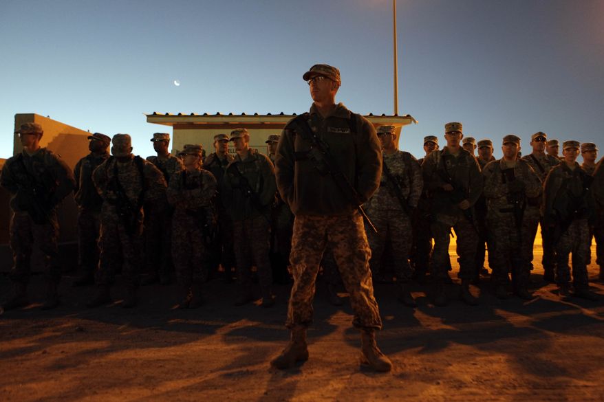 In this Dec. 3, 2010, photo, U.S. Army Sgt. 1st Class Sean Willis, 35, from Denver, N.C. stands with fellow soldiers from 1st Brigade, 3rd Infantry Division at al-Asad Air Base in western Iraq as the unit gathers before beginning their 18-hour journey home after a year in Iraq. The first time Sgt. 1st Class Willis returned from Iraq in 2003, he was whisked away to attend the birth of his son. Four deployments later, his seven-year-old son, Aidan, was on hand to meet him at Fort Stewart, Ga. More than seven years after 1st Brigade entered Baghdad as the first conventional U.S. forces in Iraq, its soldiers are coming home from a yearlong deployment that saw the end of combat operations.  (AP Photo/Maya Alleruzzo)