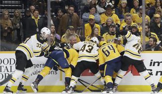 A group of Boston Bruins and Nashville Predators battle for the puck trapped against the boards in the second period of an NHL hockey game Tuesday, Jan. 7, 2020, in Nashville, Tenn. (AP Photo/Mark Humphrey)