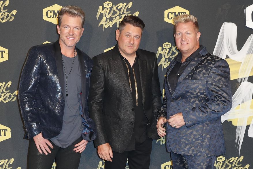 FILE - In this June 6, 2018, file photo, from left, Joe Don Rooney, Jay DeMarcus, and Gary LeVox, of Rascal Flatts, arrive at the CMT Music Awards at the Bridgestone Arena on Wednesday,, in Nashville, Tenn. The country group will bless the broken road this year on their farewell tour on their 20th anniversary together. The group announced Tuesday, Jan. 7, 2020, that they have no future plans for the band after the tour that begins in June and runs through October.(AP Photo/Al Wagner, File)