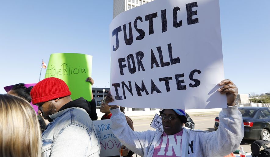 Prisoner advocates hold signs supporting inmate rights at a protest outside the Capitol in Jackson, Miss., Tuesday, Jan. 7, 2020. The protesters called on the federal government to investigate Mississippi's prison system for possible civil rights violations. They say five deaths in recent days highlights deliberate violations of inmates' constitutional rights. (AP Photo/Rogelio V. Solis)