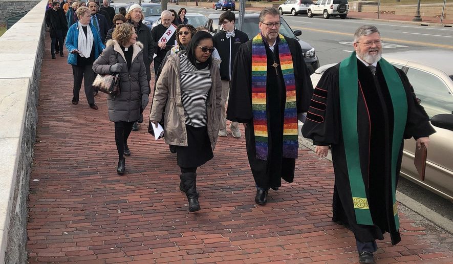 Rev. Tom Wiles, right, leads members of the Rhode Island Interfaith Coalition to Reduce Poverty on a march to the Statehouse on Tuesday, Jan. 7, 2020, to call on politicians to pass bills this year to address poverty. The new legislative session opened Tuesday. (AP Photo/ Jennifer McDermott)
