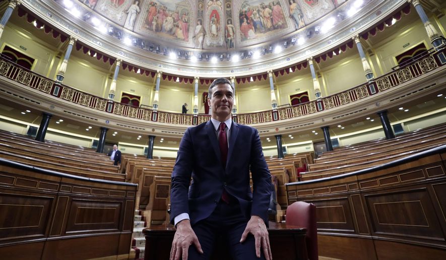 Spain's caretaker Prime Minister Pedro Sanchez poses for photographers at the Spanish parliament in Madrid Tuesday, Jan. 7, 2020. Spain's parliament chose Socialist leader Pedro Sánchez to form a new government Tuesday, ending almost a year of political limbo for the eurozone's fourth-largest economy. Sánchez won a cliff-hanger confidence vote 167-165, with 18 abstentions. It was the slimmest victory for a prime minister candidate in decades.(AP Photo/Manu Fernandez)