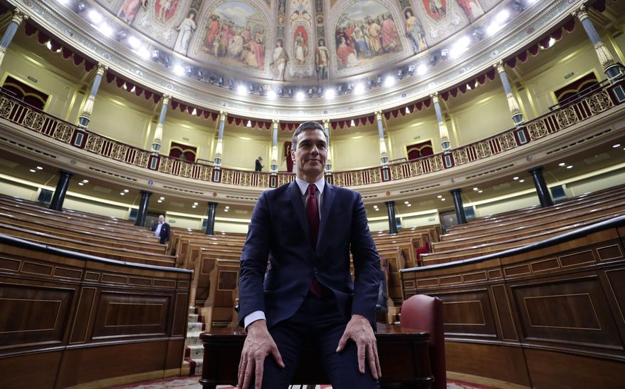 Spain's caretaker Prime Minister Pedro Sanchez poses for photographers at the Spanish parliament in Madrid Tuesday, Jan. 7, 2020. Spain's parliament chose Socialist leader Pedro Sánchez to form a new government Tuesday, ending almost a year of political limbo for the eurozone's fourth-largest economy. Sánchez won a cliff-hanger confidence vote 167-165, with 18 abstentions. It was the slimmest victory for a prime minister candidate in decades.(AP Photo/Manu Fernandez)