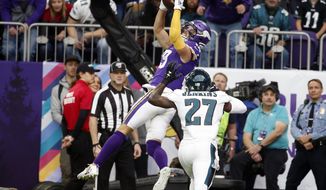 FILE - In this Sunday, Oct. 13, 2019 file photo, Minnesota Vikings wide receiver Adam Thielen, left, tries to catch a pass over Philadelphia Eagles strong safety Malcolm Jenkins (27) during the first half of an NFL football game in Minneapolis. Adam Thielen&#39;s season has been hamstrung by a hamstring injury, but the two-time Pro Bowl wide receiver remains an integral part of the offense for the Minnesota Vikings as evidenced by his diving catch in overtime to set up the playoff game win at New Orleans. (AP Photo/Bruce Kluckhohn, File)