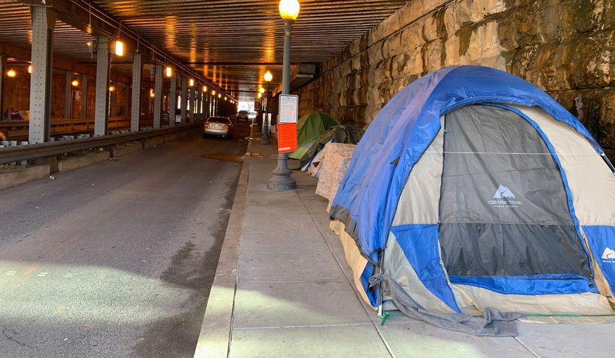 D.C. government workers cleared out all the tents on the sidewalk under the K Street Northeast underpass last week to make room for pedestrians. Many of those homeless folk moved to the L Street Northeast underpass. (Sophie Kaplan/The Washington Times)