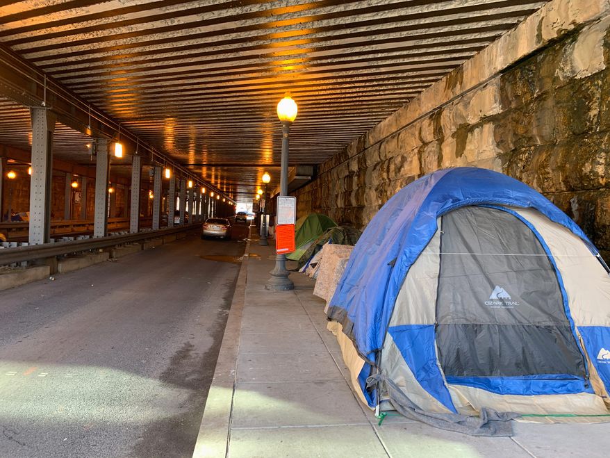 D.C. government workers cleared out all the tents on the sidewalk under the K Street Northeast underpass last week to make room for pedestrians. Many of those homeless folk moved to the L Street Northeast underpass. (Sophie Kaplan/The Washington Times)