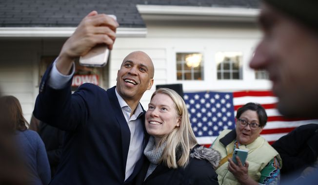 Democratic presidential candidate Sen. Cory Booker, D-N.J., poses for a selfie with an attendee after speaking at a campaign event at the home of Polk County Democratic Chair Sean Bagniewski, Tuesday, Jan. 7, 2020, in Des Moines, Iowa. Booker said a looming impeachment trial and other pressing issues in Washington could deal a big, big blow to his Democratic presidential campaign by keeping him away from Iowa in the final weeks before the Feb. 3 caucuses. (AP Photo/Patrick Semansky)