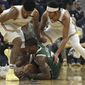 Milwaukee Bucks&#39; Eric Bledsoe, center, keeps the ball from Golden State Warriors&#39; Jacob Evans left, and Damion Lee, right, during the first half of an NBA basketball game Wednesday, Jan. 8, 2020, in San Francisco. (AP Photo/Ben Margot)