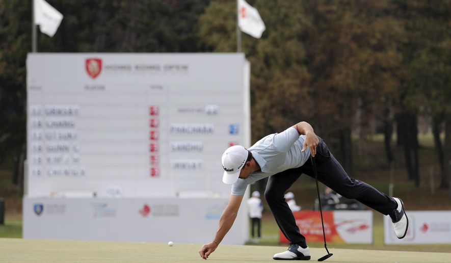 Wade Ormsby of Australia clears for his putt on the 18th hole during the Hong Kong Open golf tournament at Fanling Golf Club in Hong Kong, Thursday, Jan. 9, 2020. (AP Photo/Andy Wong)