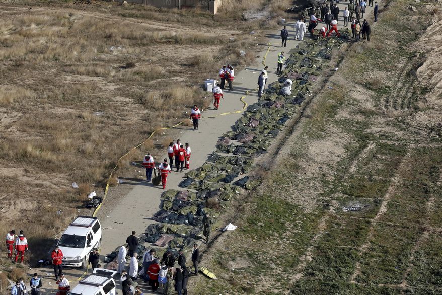 FILE - In this Wednesday, Jan. 8, 2020 file photo, bodies of victims of a Ukrainian plane crash are collected by rescue team at the scene of the crash in Shahedshahr, southwest of the capital Tehran, Iran. Two U.S. officials said Thursday that it was “highly likely” that an Iranian anti-aircraft missile downed a Ukrainian jetliner late Tuesday, killing all 176 people on board. President Donald Trump is suggesting he believes Iran was responsible. (AP Photo/Ebrahim Noroozi, File)