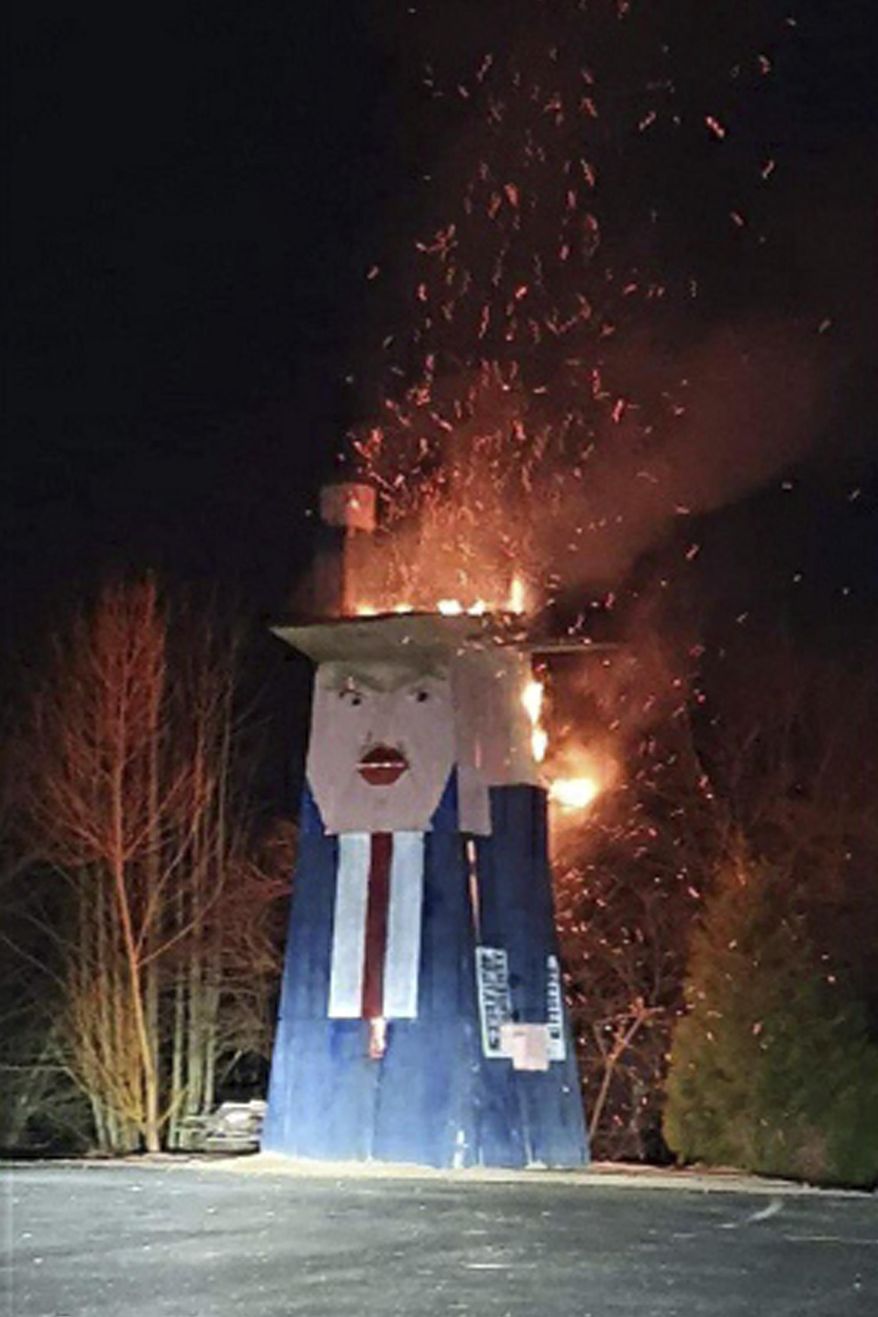 In this photo provided by the municipality of Moravce, wooden sculpture resembling U.S. president Trump is on fire, in Moravce, Slovenia, Thursday, Jan. 9, 2020. The wooden nearly eight-meter high (26 feet) statue mocking U.S. President Donald Trump that was constructed last year, has been destroyed by fire in the homeland of his wife Melania Trump. (Municipality of Moravce via AP)