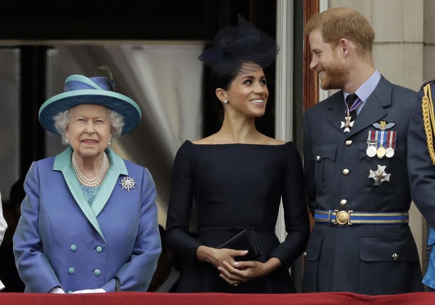 In this Tuesday, July 10, 2018, file photo Britain&#39;s Queen Elizabeth II, and Meghan the Duchess of Sussex and Prince Harry watch a flypast of Royal Air Force aircraft pass over Buckingham Palace in London. (AP Photo/Matt Dunham, File)