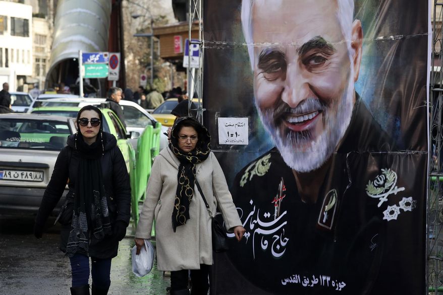 Women walk past a banner of Iranian Revolutionary Guard Gen. Qassem Soleimani, who was killed in Iraq in a U.S. drone attack on Friday, in Tajrish square in northern Tehran, Iran, Thursday, Jan. 9, 2020. Many Iranians say they are relieved that neither their country nor the United States appear primed right now for a more direct military confrontation that could lead to war. (AP Photo/Vahid Salemi)