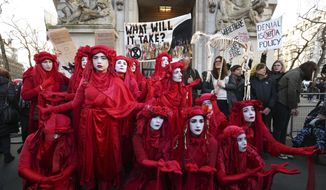 The Red Rebels join climate change protesters outside the Australian Embassy in London, where Extinction Rebellion are staging a protest against the Australian government&#x27;s response to the wildfires in Australia, Friday Jan. 10, 2020. (Jonathan Brady/PA via AP)