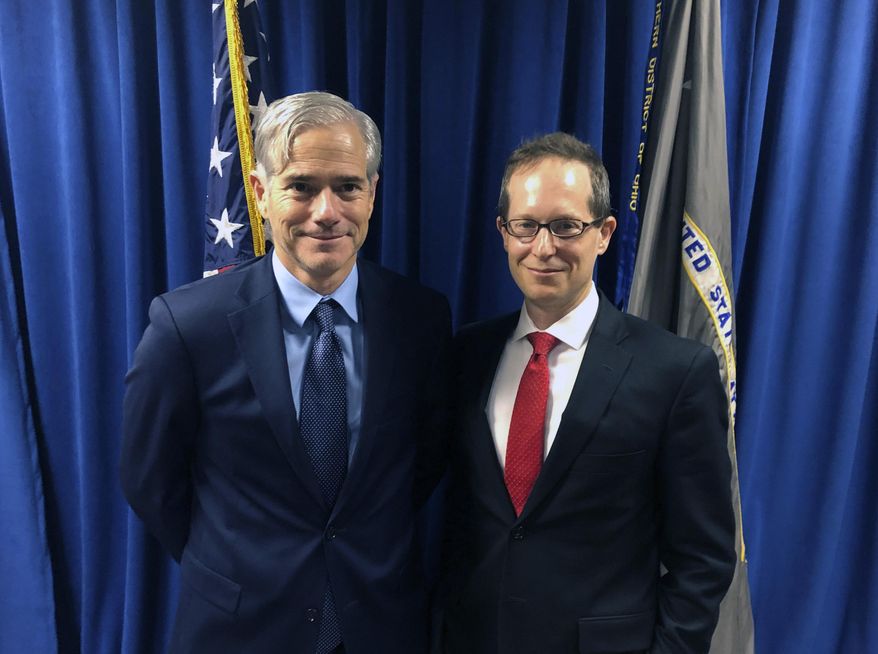 In this Tuesday, Oct. 29, 2018, photo David DeVillers, left, a veteran prosecutor confirmed this week by the U.S. Senate to become U.S. Attorney for southern Ohio, stands with current U.S. Attorney Benjamin C. Glassman in the federal prosecutor's offices in Cincinnati. David DeVillers has been formally sworn into office, Friday, Jan. 10, 2020. (AP Photo/Dan Sewell)